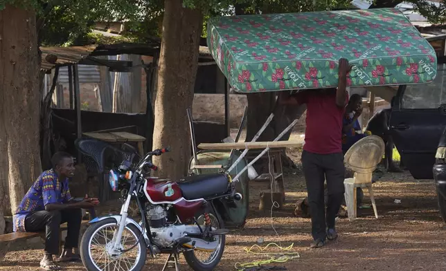 A man carries belongings and prepares to leave following an attack by gunmen in Yelewata community north-central Nigeria, Monday, June 16, 2025. (AP Photo)