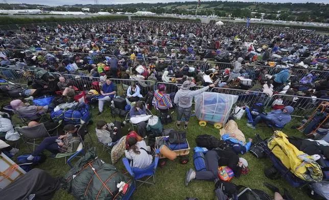 Revellers queue for entry, on the first day of the Glastonbury Festival at Worthy Farm, in Somerset. England, Wednesday June 25, 2025. (Yui Mok/PA via AP)