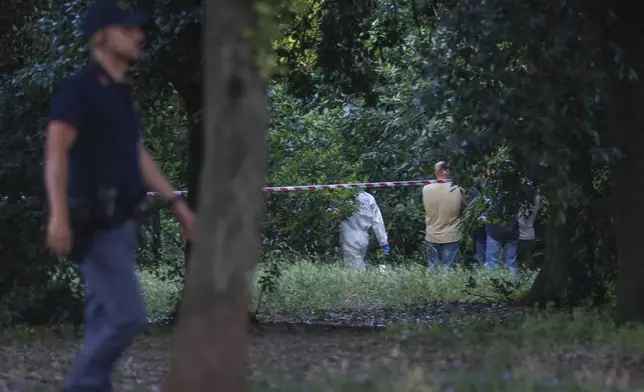 A police officer walks past a sealed off area where forensic police work at the site of the discovery of the body of an infant and the infant’s mother, in Rome’s Villa Pamphili park, Saturday, June 7, 2025. (Francesco Benvenuti/LaPresse via AP)