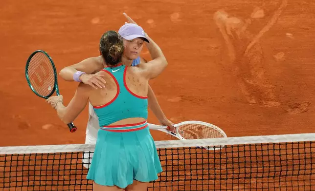 Winner Aryna Sabalenka of Belarus, back to the camera, and Poland's Iga Swiatek hug after their semifinal match of the French Tennis Open at the Roland-Garros stadium in Paris, Thursday, June 5, 2025. (AP Photo/Aurelien Morissard)
