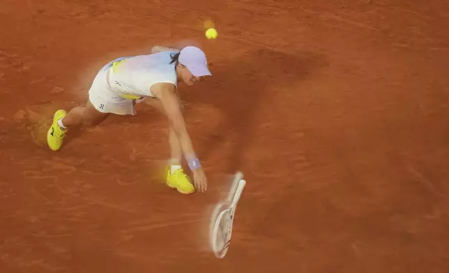 Poland's Iga Swiatek is reflected in a glass as she plays a shot against Aryna Sabalenka of Belarus during their semifinal match of the French Tennis Open at the Roland-Garros stadium in Paris, Thursday, June 5, 2025. (AP Photo/Aurelien Morissard)