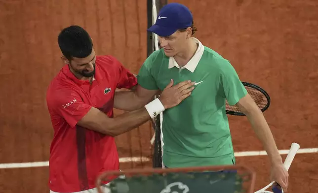 Winner Italy's Jannik Sinner, right, and Serbia's Novak Djokovic greet each other after their semifinal match of the French Tennis Open at the Roland-Garros stadium in Paris, Friday, June 6, 2025. (AP Photo/Christophe Ena)