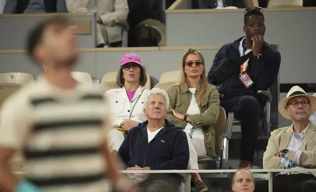 Actor Dustin Hoffman, centre, watches the semifinal match of the French Tennis Open between Italy's Lorenzo Musetti and Spain's Carlos Alcaraz at the Roland-Garros stadium in Paris, Friday, June 6, 2025. (AP Photo/Christophe Ena)