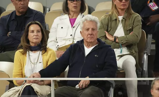 Actor Dustin Hoffman and his wife Lisa watch the semifinal match of the French Tennis Open between Italy's Lorenzo Musetti and Spain's Carlos Alcaraz at the Roland-Garros stadium in Paris, Friday, June 6, 2025. (AP Photo/Christophe Ena)