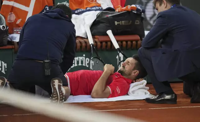 Serbia's Novak Djokovic receives medical assistance during a break at the semifinal match of the French Tennis Open at the Roland-Garros against Italy's Jannik Sinner stadium in Paris, Friday, June 6, 2025. (AP Photo/Thibault Camus)