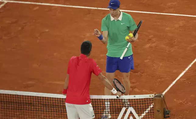 Italy's Jannik Sinner, right, talks with Serbia's Novak Djokovic during their semifinal match of the French Tennis Open at the Roland-Garros stadium in Paris, Friday, June 6, 2025. (AP Photo/Aurelien Morissard)