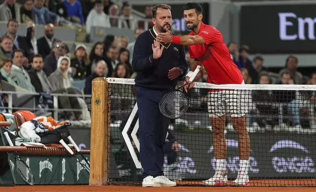 Serbia's Novak Djokovic talks with chair umpire Damien Dumusois during the semifinal match of the French Tennis Open against Italy's Jannik Sinner at the Roland-Garros stadium in Paris, Friday, June 6, 2025. (AP Photo/Lindsey Wasson)