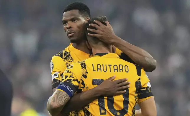 Inter Milan's Denzel Dumfries embraces teammate Lautaro Martinez at the end of the Champions League final soccer match between Paris Saint-Germain and Inter Milan at the Allianz Arena in Munich, Germany, Saturday, May 31, 2025. (AP Photo/Luca Bruno)