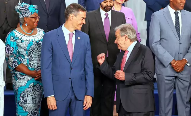 Spain's Prime Minister Pedro Sanchez, left, speaks with United Nations Secretary-General Antonio Guterres, as they pose for a photo with nation leaders and representatives, at the start of the four-day Financing for Development meeting, in Seville, Spain, Monday, June 30, 2025. (AP Photo/Jose Angel Garcia)