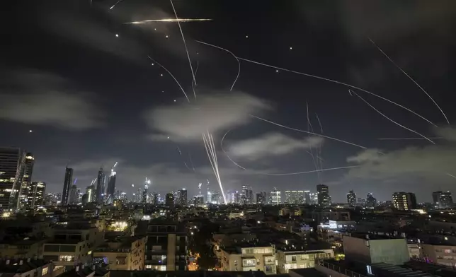 The Israeli Iron Dome air defense system fires to intercept missiles during an Iranian attack over Tel Aviv, Israel, early Wednesday, June 18, 2025. (AP Photo/Leo Correa)