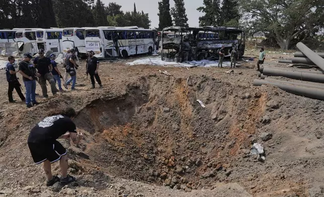 Israeli security forces inspect a site hit by a missile launched from Iran in central Israel on Tuesday, June 17, 2025. (AP Photo/Baz Ratner)