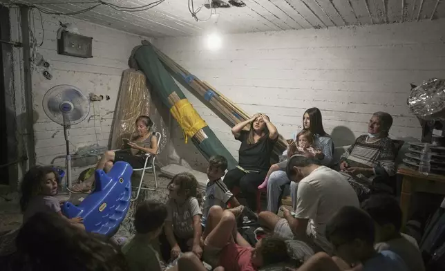 Israelis take shelter during air raid sirens warning of incoming strikes by Iran, in Bnei Brak, near Tel Aviv, Israel, Tuesday, June 17, 2025. (AP Photo/Oded Balilty)