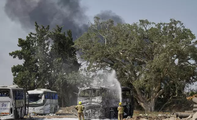 Firefighters work at site hit by a missile launched from Iran in central Israel on Tuesday, June 17, 2025. (AP Photo/Baz Ratner)