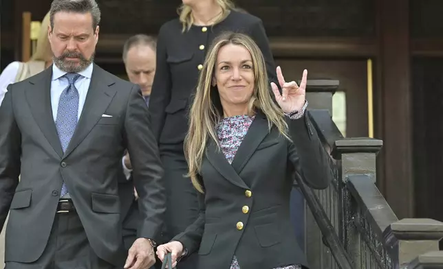 Karen Read, right, gestures to supporters as she and attorney Alan Jackson, left, leave the Dedham, Mass. courthouse, after the judge issued instructions to the jury in Read's trial at Norfolk Superior Court, Friday, June 13, 2025, in Dedham, Mass. (AP Photo/Josh Reynolds)