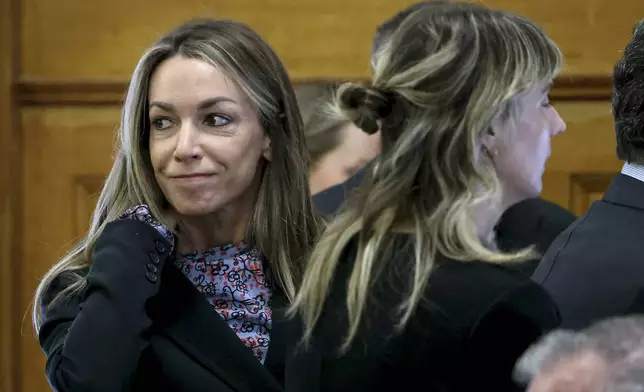 Defendant Karen Read smiles at her family before closing arguments during her murder trial in Norfolk Superior Court, Friday, June 13, 2025, in Dedham, Mass. (Mark Stockwell/The Sun Chronicle via AP, Pool) /// [EXTERNAL]