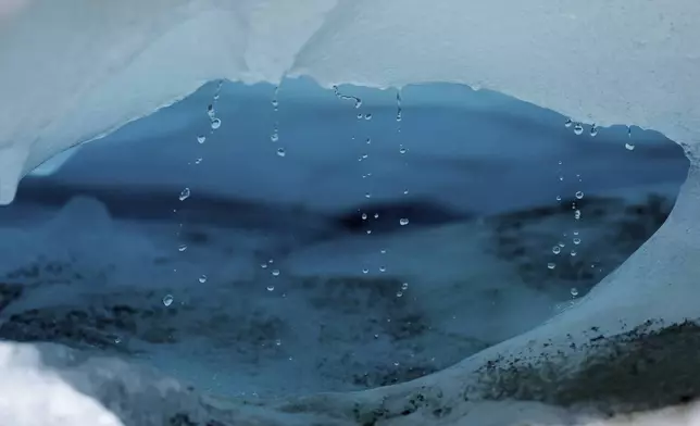 Water drips from a melting chunk of ice that originated from the Rhone Glacier near Goms, Switzerland, June 10, 2025. (AP Photo/Matthias Schrader)