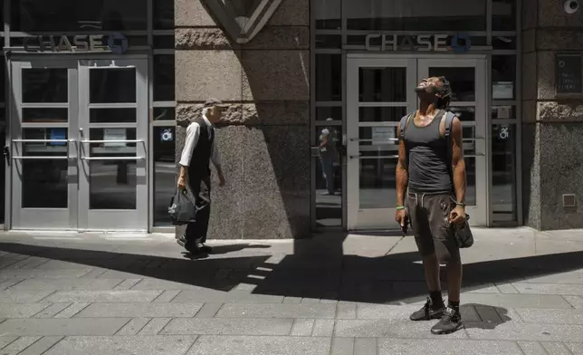 A man squints at the sun during a heatwave on Tuesday, June 24, 2025, in New York. (AP Photo/Olga Fedorova)