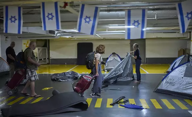 People fold tents at an underground shelter they stayed in during the war with Iran after the ceasefire was announced in Tel Aviv, Israel, Tuesday, June 24, 2025. (AP Photo/Ohad Zwigenberg)