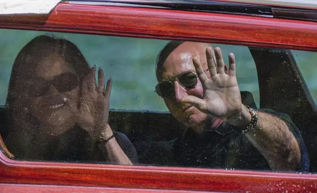 Amazon multi-billionaire founder Jeff Bezos, right, and Lauren Sanchez arrive by boat at an hotel in Venice, Italy, on Wednesday, June 25, 2025, ahead of festivities in the lagoon city reportedly linked to their wedding. (AP Photo/Luca Bruno))