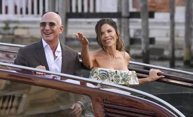 Jeff Bezos, left, and Lauren Sanchez leave a hotel for their pre-wedding reception, in Venice, Italy, Thursday, June 26, 2025. (AP Photo/Luca Bruno)