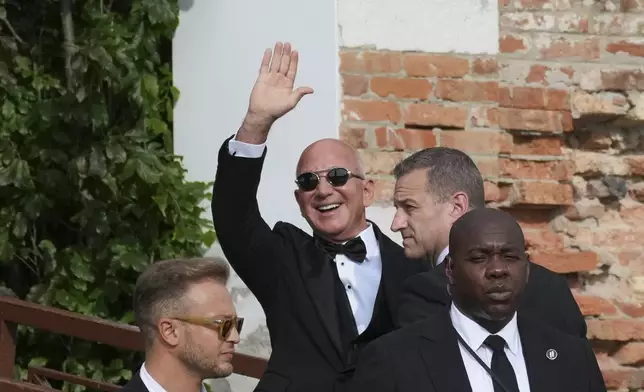 Jeff Bezos waves as he arrives at San Giorgio island ahead of the anticipated wedding celebrations with Lauren Sanchez, in Venice, Italy, Friday, June 27, 2025. (AP Photo/Antonio Calanni)