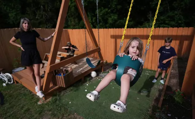 Eileen Lamb, from left, who was diagnosed with autism as an adult, watches over her children, Charlie Lamb and Jude, right, who also have autism, and daughter Billie, Monday, May 12, 2025, in Austin, Texas. (AP Photo/Eric Gay)