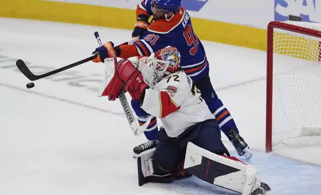 Edmonton Oilers' Evander Kane (91) tries to tip the puck past Florida Panthers goalie Sergei Bobrovsky (72) during the third period in Game 1 of the NHL Stanley Cup Final, in Edmonton, on Wednesday, June 4, 2025. (Darryl Dyck/The Canadian Press via AP)