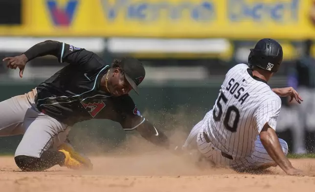 Arizona Diamondbacks shortstop Geraldo Perdomo, left, catches Chicago White Sox's Lenyn Sosa (50) stealing during the sixth inning of a baseball game Wednesday, June 25, 2025, in Chicago. (AP Photo/Erin Hooley)