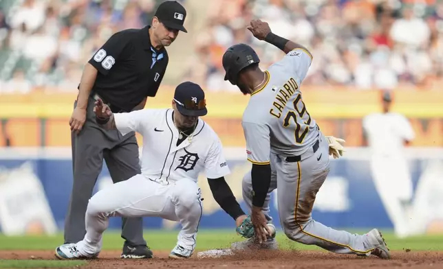 Detroit Tigers shortstop Javier Báez tags Pittsburgh Pirates' Alexander Canario (29) out attempting to steal second base as second base umpire David Rackley (86) looks on in the third inning during a baseball game, Tuesday, June 17, 2025, in Detroit. (AP Photo/Paul Sancya)