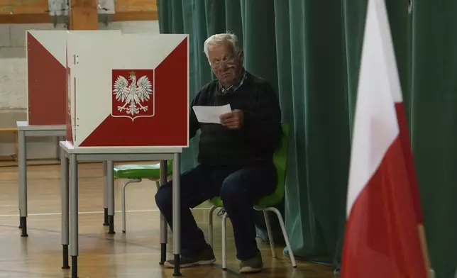 A resident prepares to cast his vote during the presidential election runoff in Warsaw, Poland, Sunday, June 1, 2025. (AP Photo/Czarek Sokolowski)