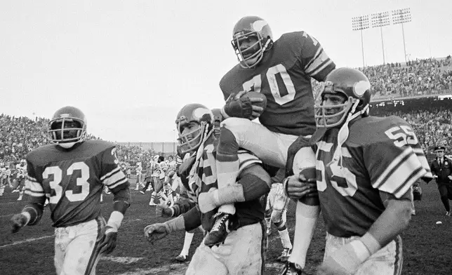 FILE - Minnesota Viking tackle Jim Marshall clutches the game ball as he is carried from the field by teammates Doug Southerland, left, and Scott Studwell after the Vikings defeated the Buffalo Bills 10-3 in an NFL football game in Bloomington, Minn., on Sunday, Dec. 9, 1979. (AP Photo/Jim Mone, File)