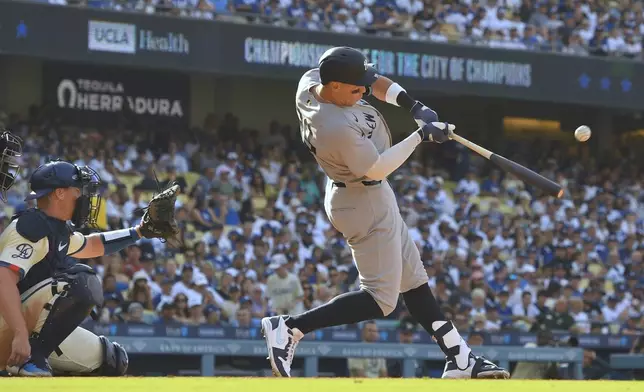 New York Yankees' Aaron Judge, right, hits a solo home run as Los Angeles Dodgers catcher Will Smith watches during the fourth inning of a baseball game Saturday, May 31, 2025, in Los Angeles. (AP Photo/Mark J. Terrill)