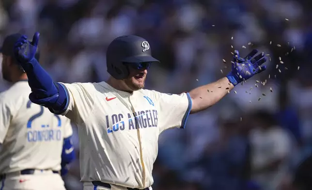 Los Angeles Dodgers' Max Muncy has seeds thrown at him after hitting a three-run home run during the second inning of a baseball game against the New York Yankees, Saturday, May 31, 2025, in Los Angeles. (AP Photo/Mark J. Terrill)