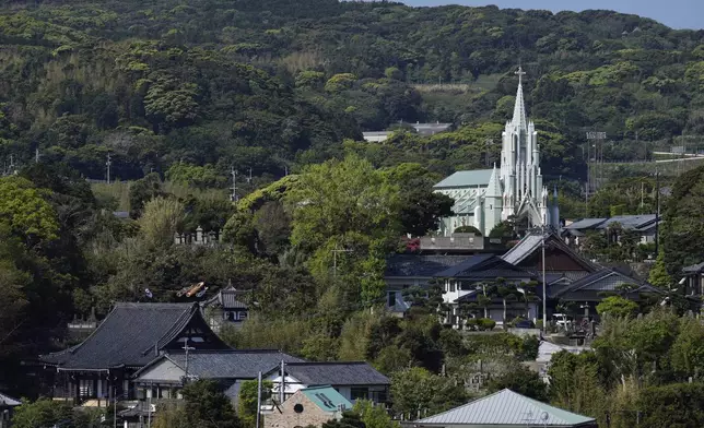 St. Francis Xavier Memorial Church, back right, looks over Zuiunji, lower left, and Komyoji Buddhist temples, in front of the church, in Ikitsuki island in Hirado, southern Japan, Tuesday, April 29, 2025. (AP Photo/Hiro Komae)