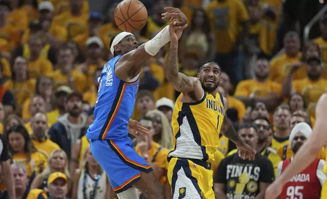 Oklahoma City Thunder guard Shai Gilgeous-Alexander (2) and Indiana Pacers forward Obi Toppin (1) battle for the ball during the second half of Game 4 of the NBA Finals basketball series, Friday, June 13, 2025, in Indianapolis. (AP Photo/Michael Conroy)