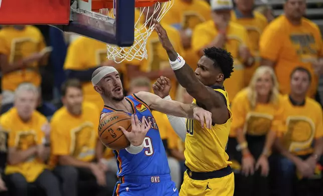 Oklahoma City Thunder guard Alex Caruso (9) drives on Indiana Pacers guard Bennedict Mathurin during the first half of Game 4 of the NBA Finals basketball series, Friday, June 13, 2025, in Indianapolis. (AP Photo/Abbie Parr)