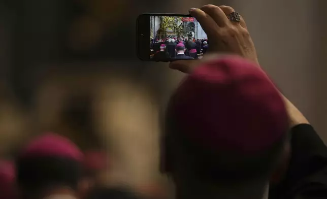 A Bishop takes photos as he attends the Pope Leo XIV leading a meditation with the participants into the Jubilee of Bishops inside St. Peter's Basilica, at the Vatican, Wednesday, June 25, 2025. (AP Photo/Andrew Medichini)