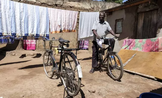 Okwir Augustine, explains how buffalo bicycle is better than the normal bicycles as he tries it out at his home in Lira district, Uganda, May 19, 2025. (AP Photo/Hajarah Nalwadda)