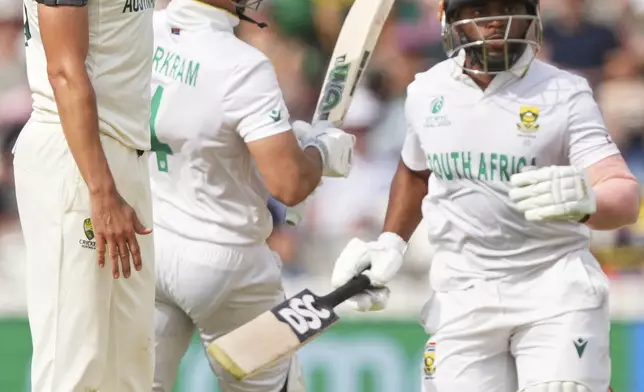 Australia's Mitchell Starc, left, reacts as South Africa's captain Temba Bavuma, right, and batting partner Aiden Markram run between the wickets to score on day three of the World Test Championship final between South Africa and Australia at Lord's cricket ground in London, Friday, June 13, 2025. (AP Photo/Kirsty Wigglesworth)