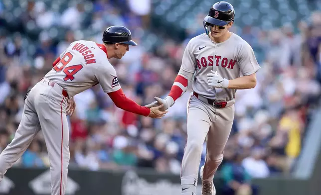 Boston Red Sox's Roman Anthony, right, is greeted by third base coach Kyle Hudson after hitting a solo home run off Seattle Mariners starting pitcher Logan Gilbert during the first inning of a baseball game Monday, June 16, 2025, in Seattle. (AP Photo/John Froschauer)