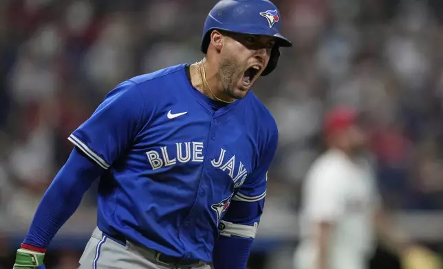 Toronto Blue Jays' George Springer shouts as he runs the bases with a home run in the eighth inning of a baseball game against the Cleveland Guardians in Cleveland, Tuesday, June 24, 2025. (AP Photo/Sue Ogrocki)