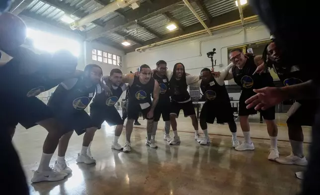 Twinning Project cohort 2 participants gather before performing basketball drills during the project's collaboration with the NBA's Golden State Warriors and the California Department of Corrections and Rehabilitation at Solano State Prison in Vacaville, Calif., Tuesday, Feb. 11, 2025. (AP Photo/Jeff Chiu)