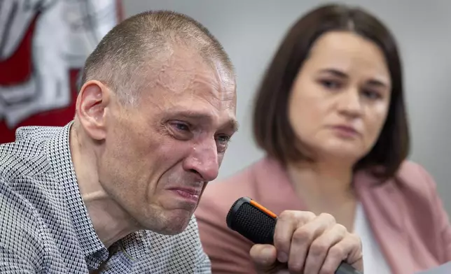 Syarhei Tsikhanouski, left, a Belarusian opposition activist released from a Belarusian prison, cries as his wife Belarusian opposition leader Sviatlana Tsikhanouskaya attends a news conference in Vilnius, Lithuania, Sunday, June 22, 2025. (AP Photo/Mindaugas Kulbis)