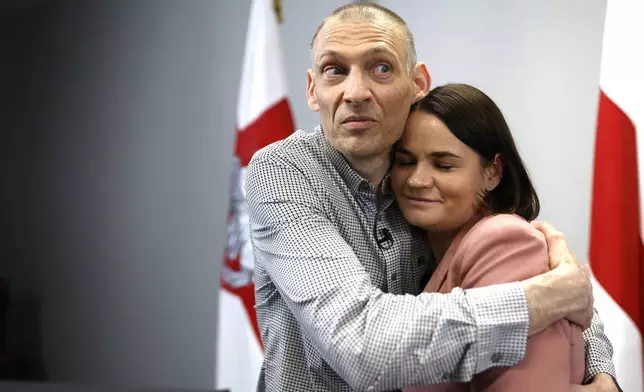 Syarhei Tsikhanouski, left, Belarusian opposition activist released from a Belarusian prison, embraces his wife, Belarusian opposition leader Sviatlana Tsikhanouskaya, after a news conference in Vilnius, Lithuania, Sunday, June 22, 2025. (AP Photo/Mindaugas Kulbis)