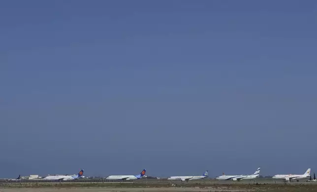 A row of aircrafts belonging to Israeli airlines El Al, Arkia, Israir sit parked in a row along the apron of Cyprus' main airport in Larnaca, Saturday, June 14, 2025. (AP Photo/Petros Karadjias)