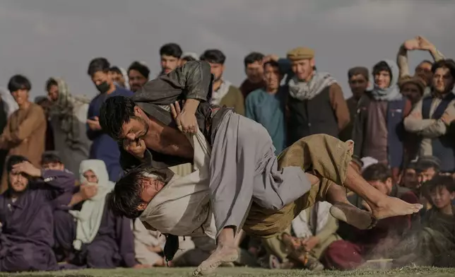 Afghans wrestlers fight during a match at the Chaman-e-Hozari Park in Kabul, Afghanistan, Friday, May 30, 2025. (AP Photo/Ebrahim Noroozi)