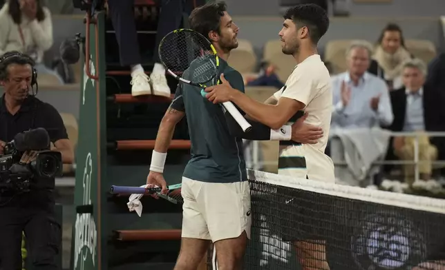 Winner Spain's Carlos Alcaraz, right, and Italy's Lorenzo Musetti greet each other after the semifinal match of the French Tennis Open at the Roland-Garros stadium in Paris, Friday, June 6, 2025. (AP Photo/Christophe Ena)