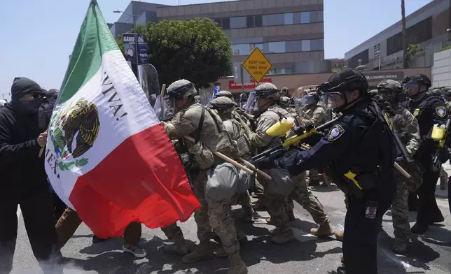 Protesters clash with authorities in downtown Los Angeles, Sunday, June 8, 2025, following last night's immigration raid protest. (AP Photo/Jae Hong)