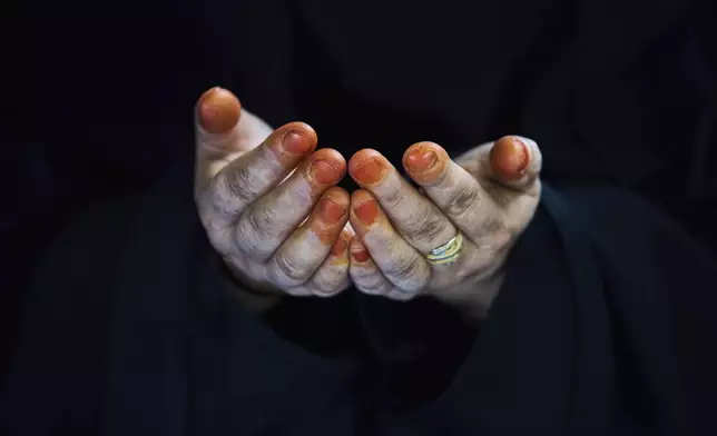A Kashmiri Muslim woman, with hands decorated with henna, prays outside the shrine of Iranian scholar and Islamic saint Shah-e-Hamadan, on his death anniversary in Srinagar, Indian controlled Kashmir, India, Tuesday, June 3, 2025. (AP Photo/Dar Yasin)