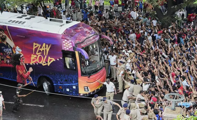 Fans cheer as the bus carrying Royal Challengers Bengaluru cricketers, winners of the Indian Premier League, arrive at the M. Chinnaswamy Stadium in Bengaluru, India, Wednesday, June 4, 2025. (AP Photo/Aijaz Rahi)